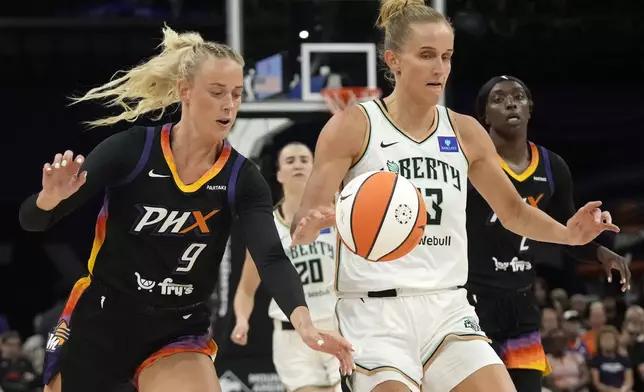 Phoenix Mercury guard Sophie Cunningham (9) tips the ball away from New York Liberty forward Leonie Fiebich, front right, during the first half of WNBA basketball game Monday, Aug. 26, 2024, in Phoenix. (AP Photo/Ross D. Franklin)