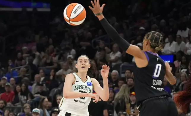 New York Liberty forward Breanna Stewart, left, gets off a pass past Phoenix Mercury guard Natasha Cloud (0) during the first half of a WNBA basketball game Monday, Aug. 26, 2024, in Phoenix. (AP Photo/Ross D. Franklin)