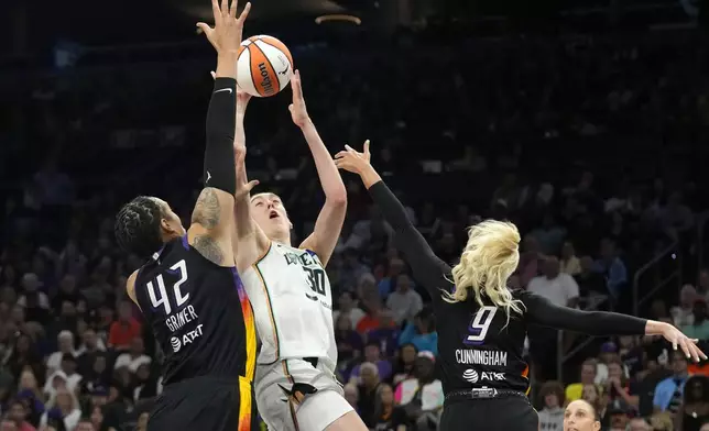 New York Liberty forward Breanna Stewart (30) tries to shoot over Phoenix Mercury center Brittney Griner (42) and guard Sophie Cunningham (9) during the first half of a WNBA basketball game Monday, Aug. 26, 2024, in Phoenix. (AP Photo/Ross D. Franklin)