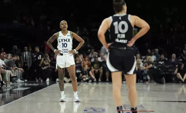 Minnesota Lynx guard Courtney Williams, left, stands on the court during the final seconds of the second half of a WNBA basketball game against the Las Vegas Aces, Wednesday, Aug. 21, 2024, in Las Vegas. (AP Photo/John Locher)