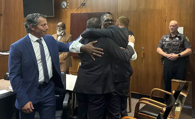 John Seiberling, Aaron Maree, center, and Gaven King embrace on Friday, Aug. 23, 2024 in Detroit, after jurors found the three men not guilty of involuntary manslaughter in a man's death at a Detroit-area mall where they were working as security guards more than 10 years ago. (AP Photo/Ed White)