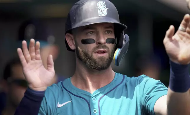 Seattle Mariners' Mitch Haniger celebrates in the dugout after scoring during the second inning of a baseball game against the Pittsburgh Pirates, Saturday, Aug. 17, 2024, in Pittsburgh. (AP Photo/Matt Freed)