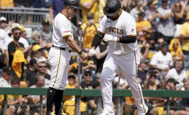 Pittsburgh Pirates' Rowdy Tellez, right, is greeted by third base coach Mike Rabelo, left, as he rounds the bases after hitting a two-run home run during the fourth inning of a baseball game against the Seattle Mariners, Saturday, Aug. 17, 2024, in Pittsburgh. (AP Photo/Matt Freed)