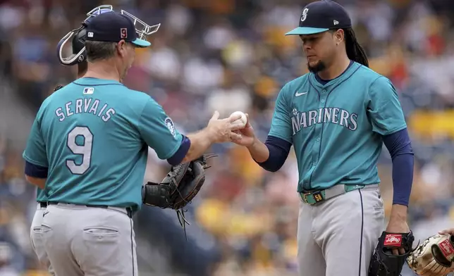 Seattle Mariners starting pitcher Luis Castillo, right, hands the ball to manager Scott Servais, left, during the sixth inning of a baseball game against the Pittsburgh Pirates, Saturday, Aug. 17, 2024, in Pittsburgh. (AP Photo/Matt Freed)