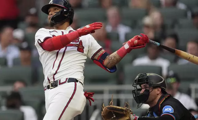 Atlanta Braves' Orlando Arcia follows through on a solo-home run as Miami Marlins catcher Nick Fortes looks on in the thrid inning of a baseball game, Thursday, Aug. 1, 2024, in Atlanta. (AP Photo/John Bazemore)