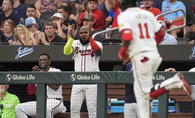 Atlanta Braves Marcell Ozuna, center, and Jorge Soler, left, react as Orlando Arcia (11) runs the bases after hitting a home run in the third inning of a baseball game against the Miami Marlins, Thursday, Aug. 1, 2024, in Atlanta. (AP Photo/John Bazemore)