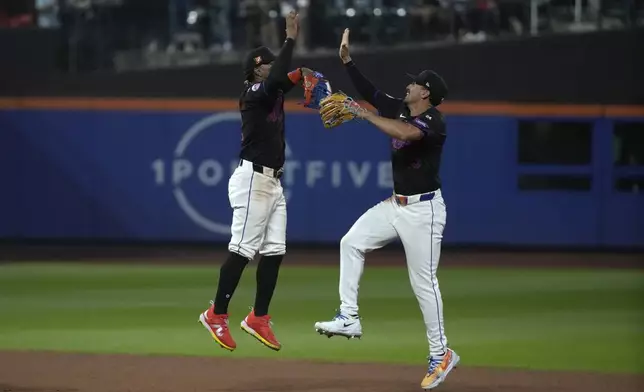 New York Mets' Francisco Lindor, left, and Tyrone Taylor, right, celebrate after winning a baseball game against the Miami Marlins, Friday, Aug. 16, 2024, in New York. (AP Photo/Pamela Smith)