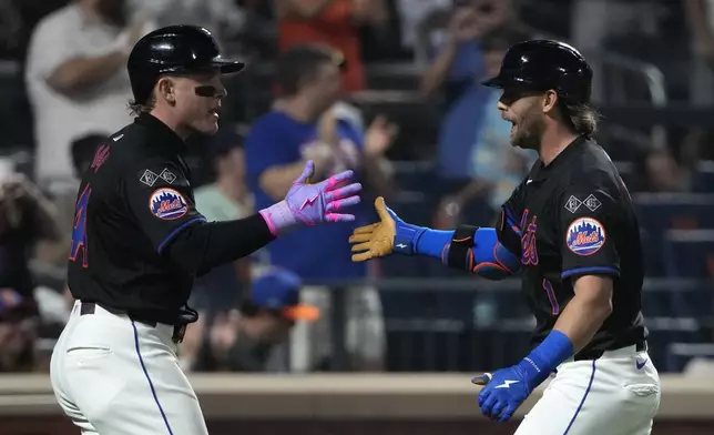 New York Mets' Harrison Bader, left, and Jeff McNeil, right, celebrate after McNeil hit a home run leading Francisco Alvarez to score during the fourth inning of a baseball game against the Miami Marlins, Friday, Aug. 16, 2024, in New York. (AP Photo/Pamela Smith)