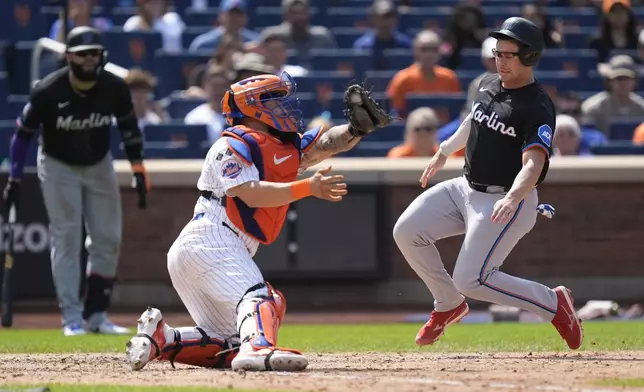 Miami Marlins' Jonah Bride, right, scores past New York Mets catcher Francisco Alvarez on a single hit by Derek Hill during the eighth inning of a baseball game at Citi Field, Sunday, Aug. 18, 2024, in New York. The Marlins defeated the Mets 3-2. (AP Photo/Seth Wenig)