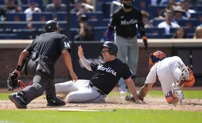 Miami Marlins' Jonah Bride, center, scores past New York Mets catcher Francisco Alvarez, right, on a single hit by Derek Hill during the eighth inning of a baseball game at Citi Field, Sunday, Aug. 18, 2024, in New York. The Marlins defeated the Mets 3-2. (AP Photo/Seth Wenig)