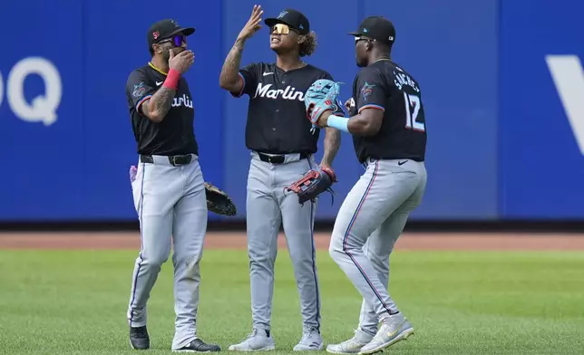 Miami Marlins' outfielders Derek Hill, left, Cristian Pache, center, and Jesús Sánchez, right, celebrate after a baseball game against the New York Mets at Citi Field, Sunday, Aug. 18, 2024, in New York. (AP Photo/Seth Wenig)