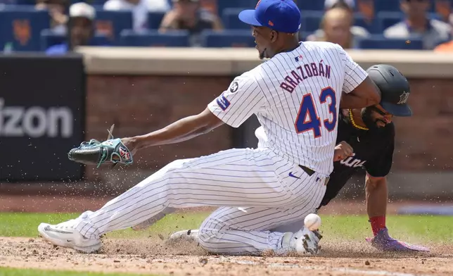 Miami Marlins' Derek Hill, right, scores past New York Mets pitcher Huascar Brazobán (43) after a wild pitch during the seventh inning of a baseball game at Citi Field, Sunday, Aug. 18, 2024, in New York. (AP Photo/Seth Wenig)