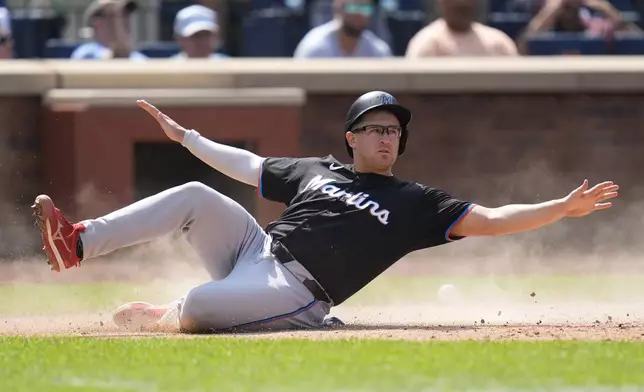 Miami Marlins' Jonah Bride slides into home plate on a single hit by Derek Hill during the eighth inning of a baseball game against the New York Mets at Citi Field, Sunday, Aug. 18, 2024, in New York. The Marlins defeated the Mets 3-2. (AP Photo/Seth Wenig)