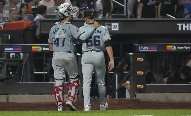 Miami Marlins' Ali Sánchez, left, and John McMillon, right, walk to the dugout together after the eighth inning of a baseball game against the New York Mets, Friday, Aug. 16, 2024, in New York. (AP Photo/Pamela Smith)