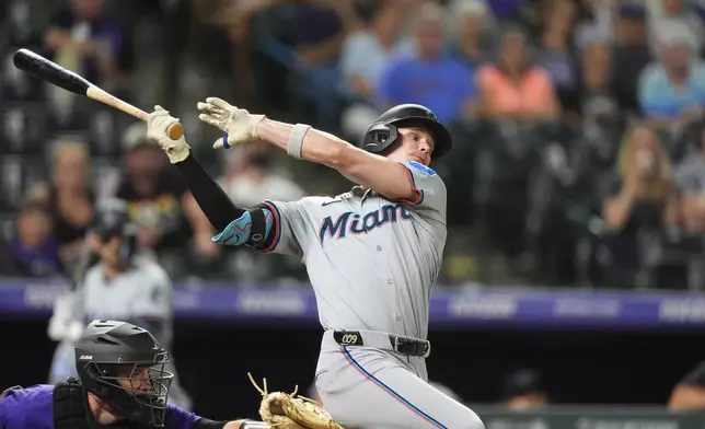 Miami Marlins pinch-hitter Griffin Conine, right, swings at a pitch while facing Colorado Rockies relief pitcher Tyler Kinley in the ninth inning of a baseball game Monday, Aug. 26, 2024, in Denver. (AP Photo/David Zalubowski)