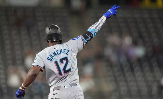 Miami Marlins' Jesus Sanchez gestures as he circles three-run home run off Colorado Rockies relief pitcher Angel Chivilli in the ninth inning of after a baseball game Tuesday, Aug. 27, 2024, in Denver. (AP Photo/David Zalubowski)