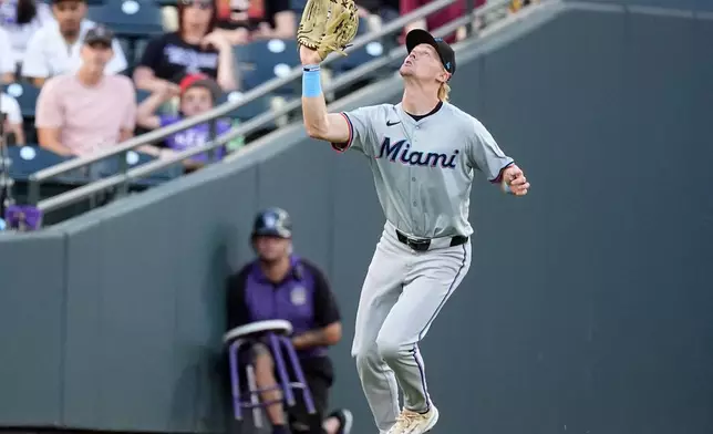 Miami Marlins left fielder Kyle Stowers pulls in a fly ball off the bat of Colorado Rockies' Ryan McMahon to end the first inning of a baseball game Monday, Aug. 26, 2024, in Denver. (AP Photo/David Zalubowski)