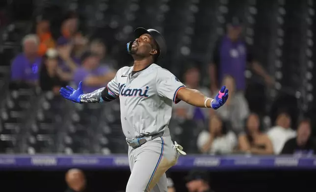 Miami Marlins' Jesus Sanchez gestures as he crosses home plate after hitting a three-run home run off Colorado Rockies relief pitcher Angel Chivilli in the ninth inning of after a baseball game Tuesday, Aug. 27, 2024, in Denver. (AP Photo/David Zalubowski)