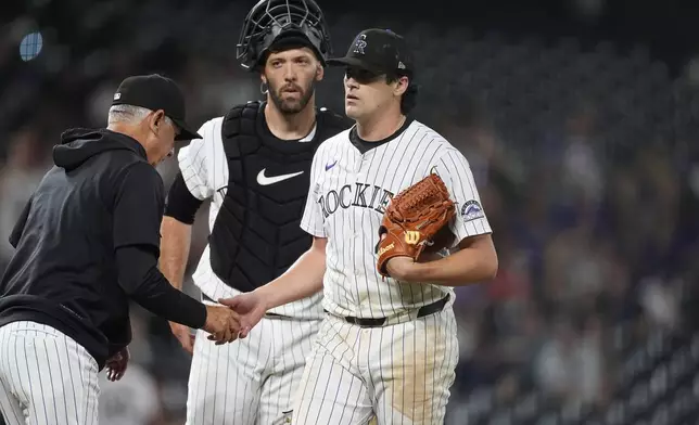 Colorado Rockies manager Bud Black, left, takes the ball from starting pitcher Cal Quantrill, right, as he is pulled from the mound while catcher Jacob Stallings looks on in the sixth inning of a baseball game against the Miami Marlins Tuesday, Aug. 27, 2024, in Denver. (AP Photo/David Zalubowski)