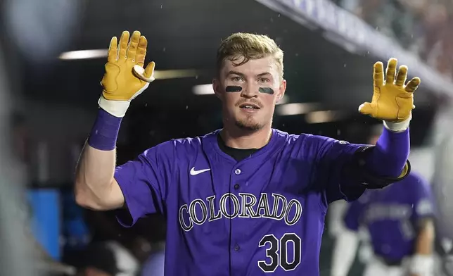 Colorado Rockies' Aaron Schunk looks on as he returns to the dugout after hitting his first major league home run, a solo shot off Miami Marlins starting pitcher Max Meyer, in the fifth inning of a baseball game Wednesday, Aug. 28, 2024, in Denver. (AP Photo/David Zalubowski)