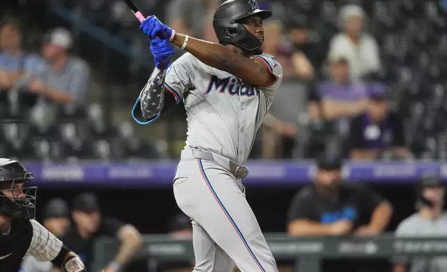 Miami Marlins' Jesus Sanchez follows the flight of his three-run home run off Colorado Rockies relief pitcher Angel Chivilli in the ninth inning of after a baseball game, Tuesday, Aug. 27, 2024, in Denver. (AP Photo/David Zalubowski)