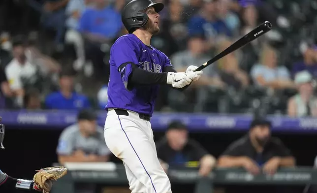 Colorado Rockies' Ryan McMahon follows the flight of his solo home run off Miami Marlins starting pitcher Edward Cabrera in the sixth inning of a baseball game Monday, Aug. 26, 2024, in Denver. (AP Photo/David Zalubowski)