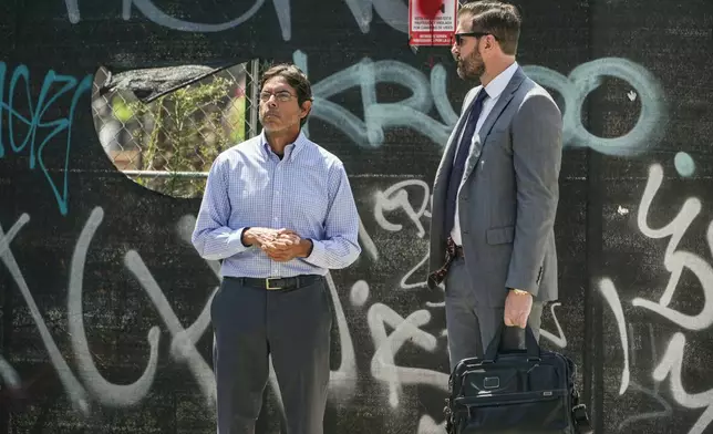 Dr. Mark Chavez, left, a physician from San Diego, who is charged in connection with actor Matthew Perry's death from an accidental ketamine overdose, waits to cross the street with his attorney Matthew Binninger across from the Roybal Federal Courthouse in Los Angeles, Friday, Aug. 30, 2024. (AP Photo/Damian Dovarganes)