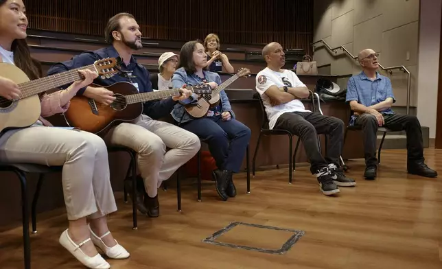 Ron Spitzer, a stroke survivor, right, sings during a music therapy session together with music therapist, Christopher Pizzute, second left, and researcher fellow, Jessica Hariwijaya, left, at Mount Sinai Hospital, on Monday, July 15, 2024, in New York. (AP Photo/Andres Kudacki)