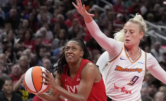 Indiana Fever's Kelsey Mitchell, left, goes to the basket against Phoenix Mercury's Sophie Cunningham (9) during the second half of a WNBA basketball game, Friday, Aug. 16, 2024, in Indianapolis. (AP Photo/Darron Cummings)