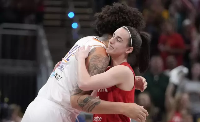 Indiana Fever guard Caitlin Clark, right, hugs Phoenix Mercury's Brittney Griner (42) before a WNBA basketball game, Friday, Aug. 16, 2024, in Indianapolis. (AP Photo/Darron Cummings)