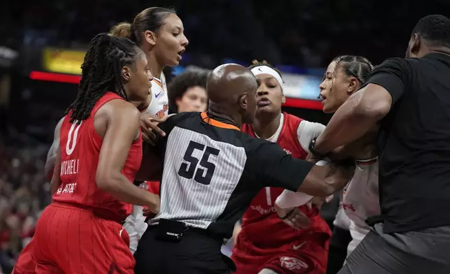 Indiana Fever's Kelsey Mitchell, left, and Phoenix Mercury's Natasha Cloud, second from right, have to be separated during the second half of a WNBA basketball game, Friday, Aug. 16, 2024, in Indianapolis. (AP Photo/Darron Cummings)