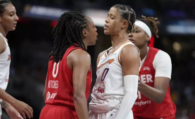 Indiana Fever's Kelsey Mitchell (0) and Phoenix Mercury's Natasha Cloud (0) have to be separated during the second half of a WNBA basketball game, Friday, Aug. 16, 2024, in Indianapolis. (AP Photo/Darron Cummings)