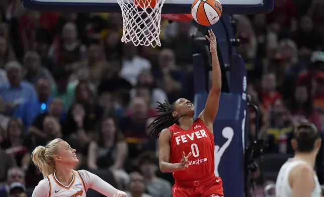 Indiana Fever guard Kelsey Mitchell (0) shoots against Phoenix Mercury's Sophie Cunningham during the first half of a WNBA basketball game, Friday, Aug. 16, 2024, in Indianapolis. (AP Photo/Darron Cummings)