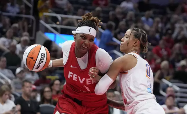 Indiana Fever forward NaLyssa Smith (1) goes to the basket against Phoenix Mercury's Natasha Cloud (0) during the second half of a WNBA basketball game, Friday, Aug. 16, 2024, in Indianapolis. (AP Photo/Darron Cummings)