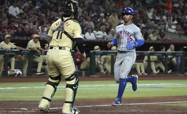 New York Mets' Francisco Lindor (12) scores a run against the Arizona Diamondbacks on a sacrifice fly out by Jesse Winker in the fifth inning during a baseball game, Tuesday, Aug 27, 2024, in Phoenix. (AP Photo/Rick Scuteri)