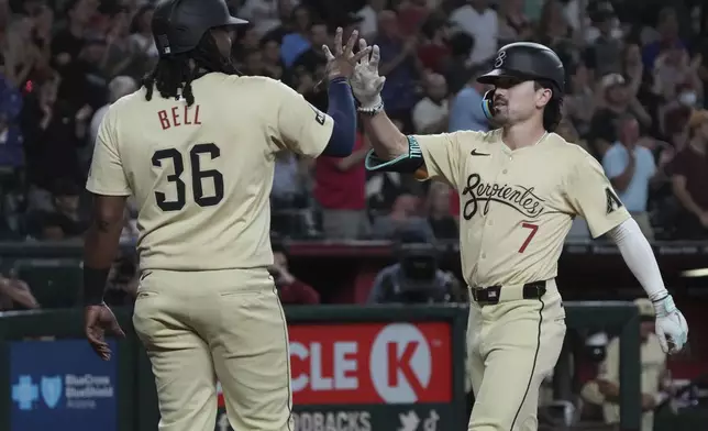 Arizona Diamondbacks' Corbin Carroll, right, celebrates with Josh Bell (36) after hitting a two-run home run against the New York Mets in the seventh inning during a baseball game Tuesday, Aug 27, 2024, in Phoenix. (AP Photo/Rick Scuteri)