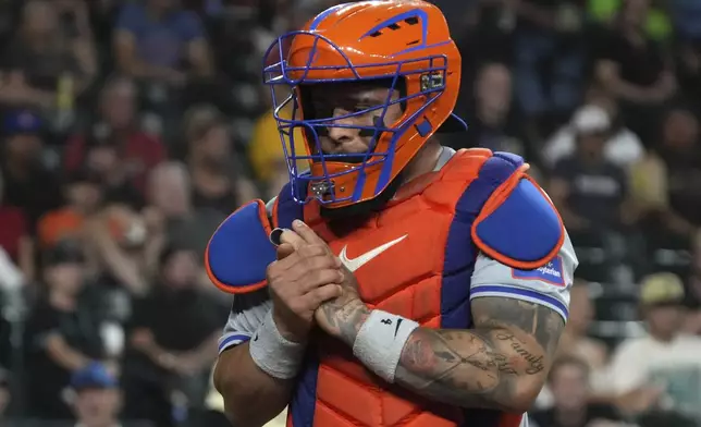 New York Mets catcher Francisco Alvarez reacts after getting hit by the swing from Arizona Diamondbacks' Josh Bell in the fourth inning during a baseball game Tuesday, Aug 27, 2024, in Phoenix. (AP Photo/Rick Scuteri)