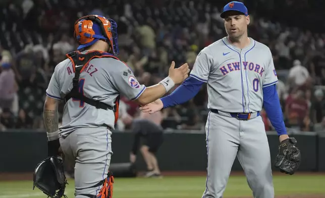 New York Mets catcher Francisco Alvarez (4) and pitcher Adam Ottavino (0) celebrate after defeating the Arizona Diamondbacks during a baseball game Tuesday, Aug 27, 2024, in Phoenix. (AP Photo/Rick Scuteri)