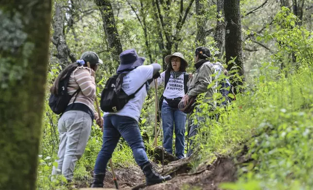 Catholic nun Paola Clerico, center, Anglican priest Rev. Arturo Carrasco, right, accompany members of the search collective "Uniendo Esperanzas" or Uniting Hope, as they take a break from their search for human remains in a forest in the State of Mexico, Mexico, Friday, Aug. 16, 2024. Second from left is Angelica Montelongo whose husband Rafael went missing when he did not return home from work in 2021. At far left is a theologist who works with Clerico and is studying anthropology. (AP Photo/Ginnette Riquelme)