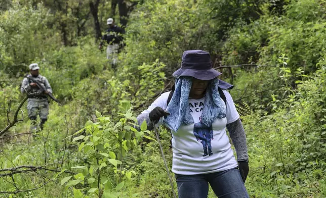 Angelica Montelongo, of the search collective "Uniendo Esperanzas" or Uniting Hope, wears a T-shirt featuring her missing husband Rafael as members of the collective are accompanied by National Guards at the end of their search for human remains in a forest in the State of Mexico, Mexico, Friday, Aug. 16, 2024. Rafael went missing when he did not return home from work in 2021. (AP Photo/Ginnette Riquelme)