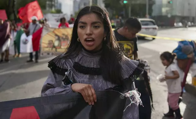 A woman shouts out slogans in support of the 43 Ayotzinapa students who went missing almost 10 years ago march to demand justice for their loved ones in Mexico City, Monday, Aug. 26, 2024. (AP Photo/Felix Marquez)