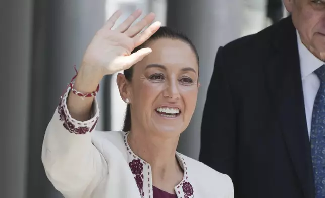 Mexican President-elect Claudia Sheinbaum, accompanied by husband Jesus Maria Tarriba, waves as she arrives to a ceremony to certify her as the winner of the presidential election at the Federal Electoral Tribunal, in Mexico City, Thursday, Aug. 15, 2024. (AP Photo/Fernando Llano)