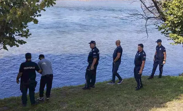 In this photograph made available by the Serbian Ministry of Interior, Serbian Police officers search a bank of the Drina River near the town of Ljubovija, Serbia, Thursday, Aug. 22, 2024. (Serbian Ministry of Interior via AP)