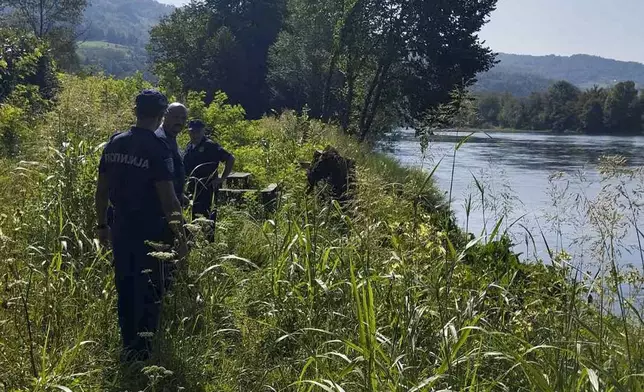 In this photograph made available by the Serbian Ministry of Interior, Serbian Police officers search a bank of the Drina River near the town of Ljubovija, Serbia, Thursday, Aug. 22, 2024. (Serbian Ministry of Interior via AP)