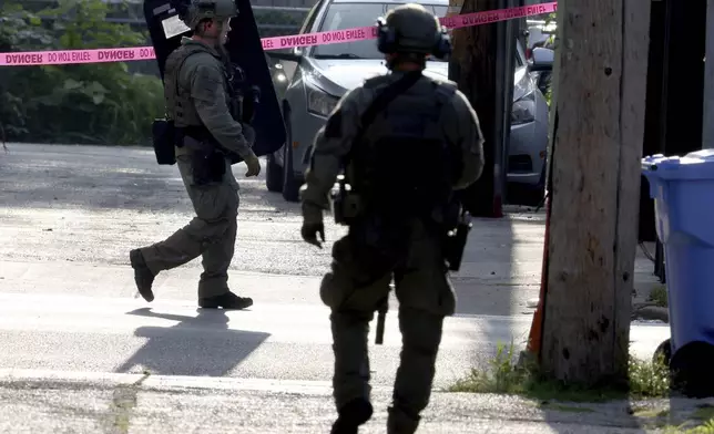 Chicago police SWAT officers patrol the area near the 2300 block of West Madison Street in Chicago, during a standoff with an escaped prisoner, Joshua Zimmerman, on Wednesday, Aug. 21, 2024 in Chicago. (Antonio Perez/Chicago Tribune via AP)