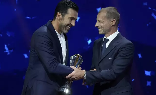 Former Juventus and PSG Italian goalkeeper Gianluigi Buffon receives the 2024 UEFA President's Award from UEFA president Aleksander Ceferin during the Champions League, league phase, draw, in Monaco, Thursday, Aug. 29, 2024. (AP Photo/Gregorio Borgia)