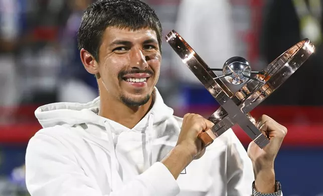 Alexei Popyrin, of Australia, holds up the winner's trophy after defeating Andrey Rublev, of Russia, in the final of the National Bank Open men's tennis tournament in Montreal, Monday, Aug. 12, 2024. (Graham Hughes/The Canadian Press via AP)