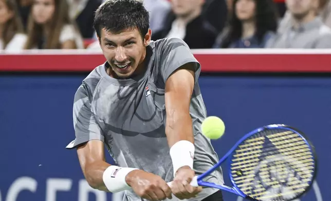 Alexei Popyrin, of Australia, plays a shot to Andrey Rublev, of Russia, during the final of the National Bank Open men's tennis tournament in Montreal, Monday, Aug. 12, 2024. (Graham Hughes/The Canadian Press via AP)