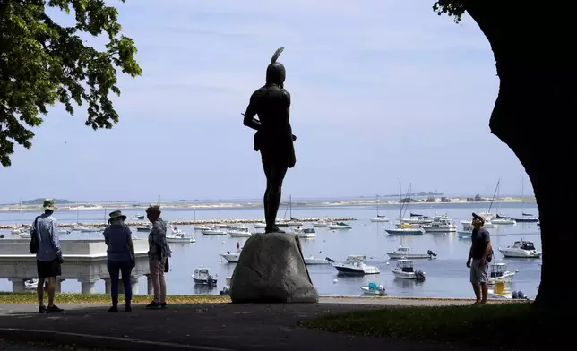 FILE - Visitors stand near a 1921 statue of the Wampanoag leader Massasoit, center, Wednesday, June 9, 2021, on Cole's Hill, in Plymouth, Mass. The town of Plymouth announced Friday, Aug. 23, 2024, that it's closing public outdoor recreation facilities from dusk until dawn each day after a horse in the town was infected with eastern equine encephalitis. (AP Photo/Steven Senne, File)