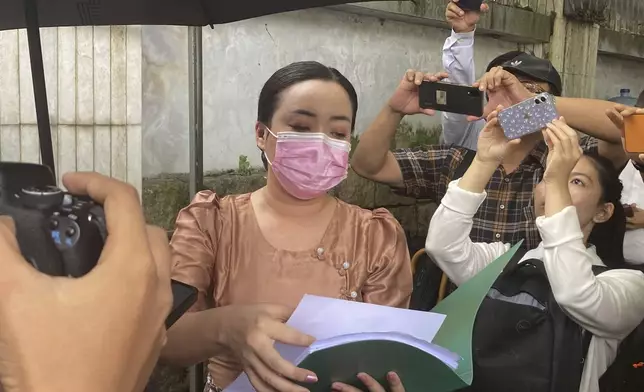 An unidentified legal official from Kamayut district court speaks outside the residence of ousted leader Aung San Suu Kyi as the home is auctioned in Yangon, MyanmarThursday, Aug. 15, 2024. (AP Photo/Thein Zaw)